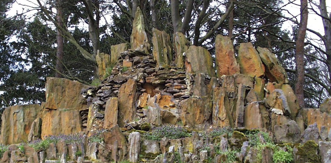 Ensemble de gros blocs de grès ferrugineux implantés par l'homme à l'intérieur du mur d'enceinte de l'Abbaye Sainte Marie du Mont des Cats.